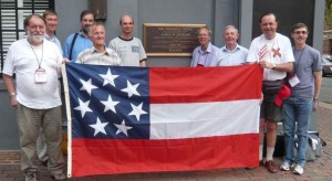 A group of vexillologists visit the site of the Marshall House Inn with a replica of the Confederate flag